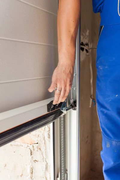 Technician repairing a residential garage door in Cambridge MA